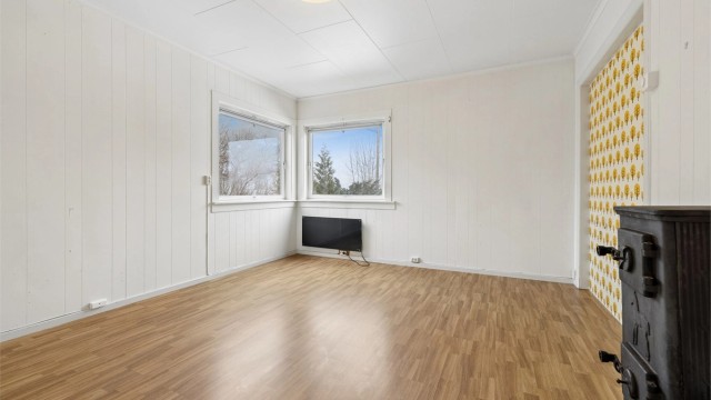 Stuen i første etasje har laminat på gulvet og en vedovn i støpejern for ekstra varme.