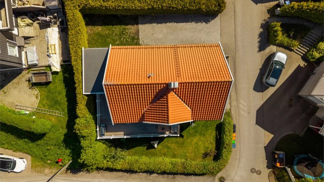 Tomten er skjermet med hekk og har en fin beliggenhet på et hjørne, og lite innsyn da eneboligen ligger nederst.