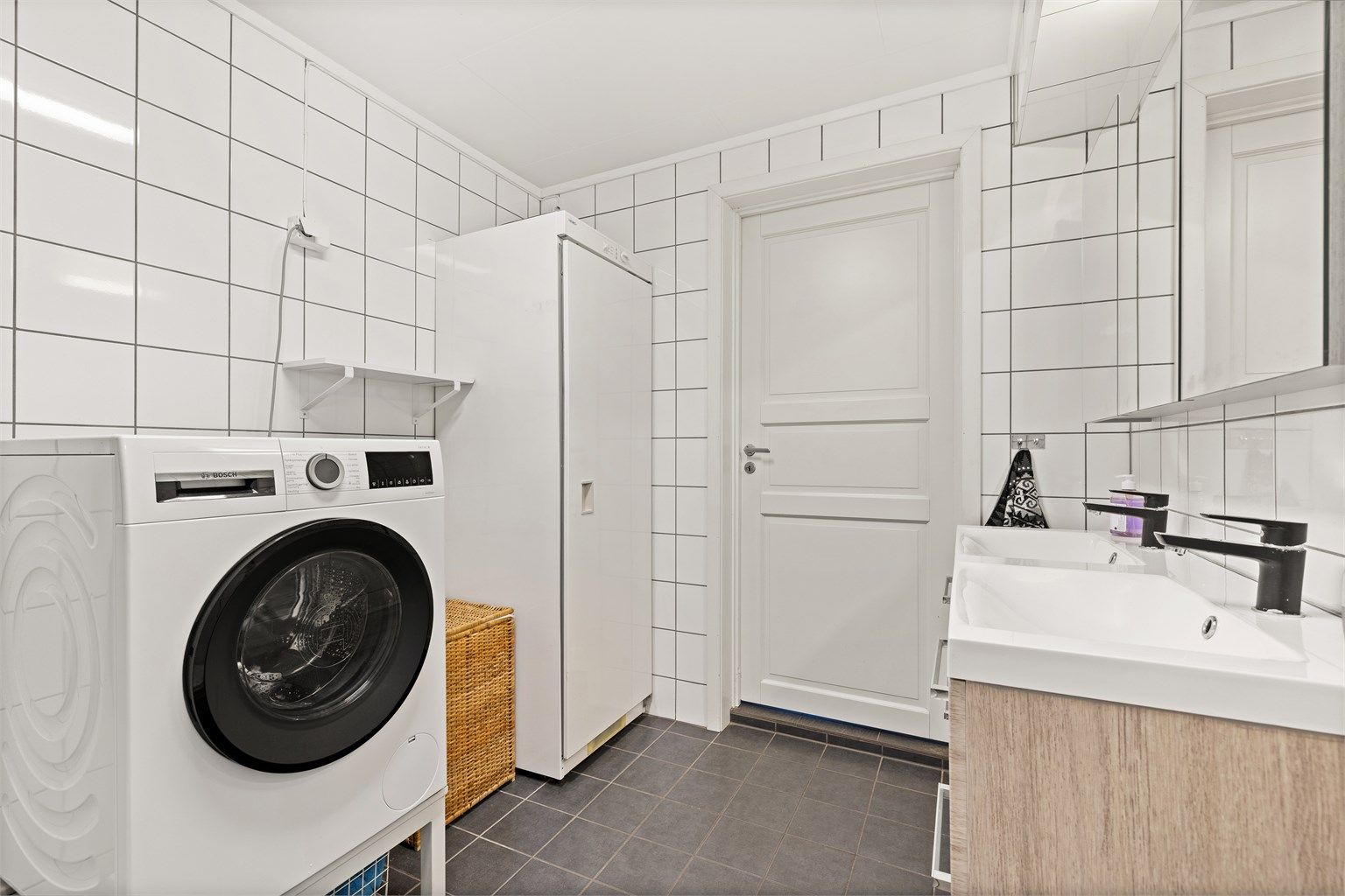 Baderommet er flislagt og har elektrisk gulvvarme for økt komfort. Dobbelt servantskap og praktisk opplegg for vaskemaskin.