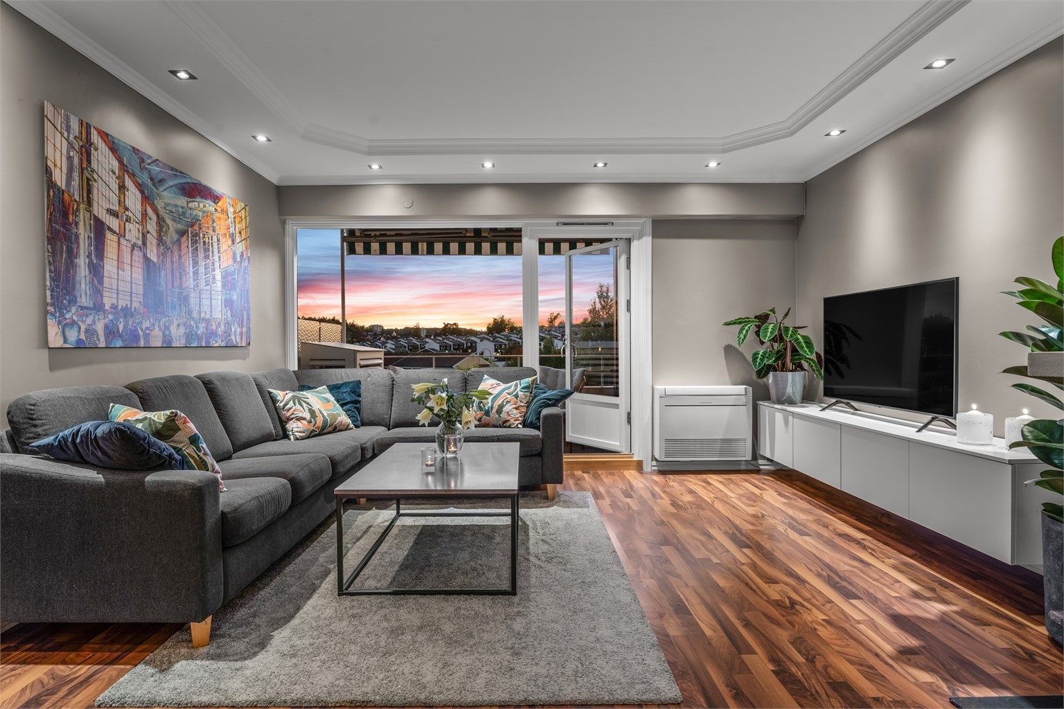 Leiligheten har en tiltalende stue med store vindusflater, som gir en lys og luftig atmosfære.