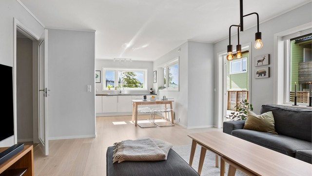 Oversikt over den åpne og luftige løsningen mellom stue og kjøkken.