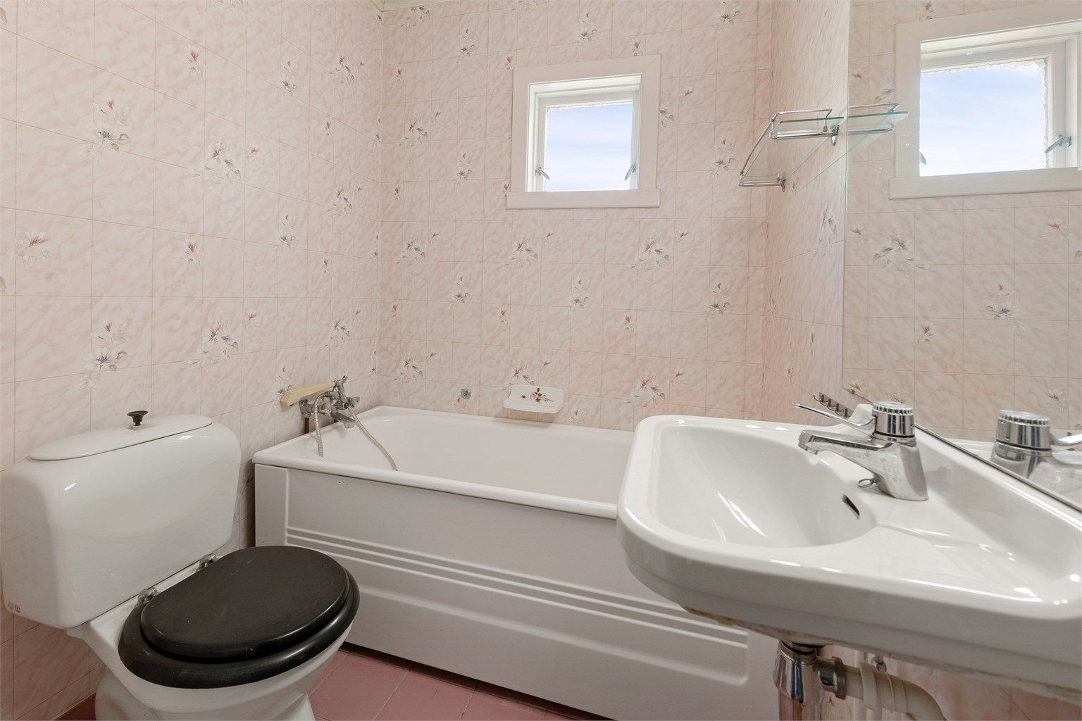 Badet i første etasje er av eldre dato og utstyrt med badekar, toalett og servant