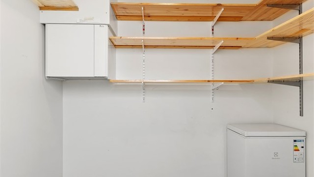 Innvendig bod innredet med hyller og god lagringsplass.