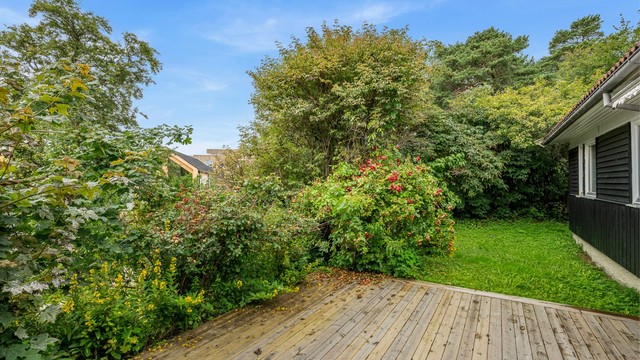 Fra stuen er det direkte utgang til terrasse og videre til den frodige hagen. Terrassen gir en hyggelig og skjermet uteplass – selger opplyser om solforhold fra ca. kl. 09 til 21 på sommerstid.