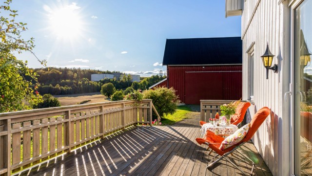Fra verandaen har man åpent utsyn mot gårdstunet og landskapet rundt.