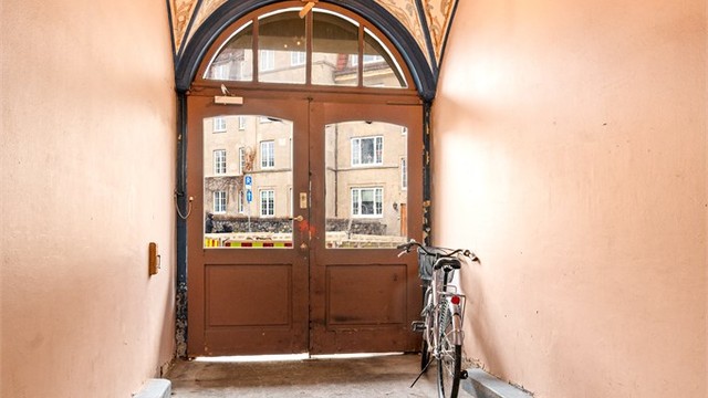 Et staselig portrom med dekormaling ønsker deg velkommen inn i bygården.