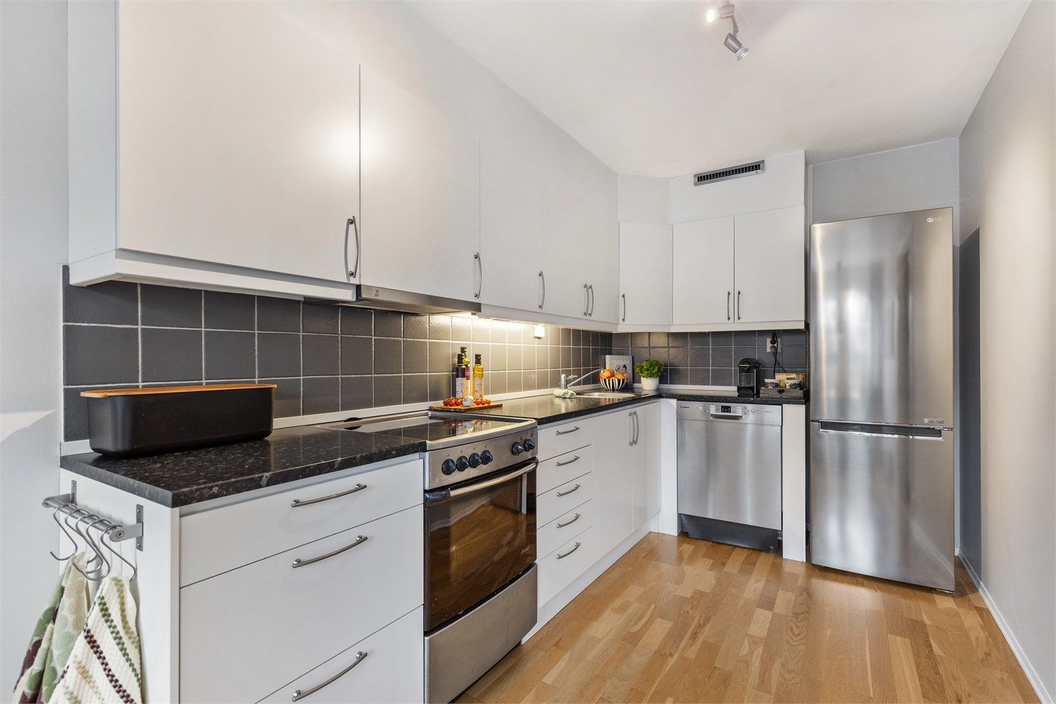 Kjøkkenet har en tidløs innredning med glatte fronter og godt med skap- og benkeplass.