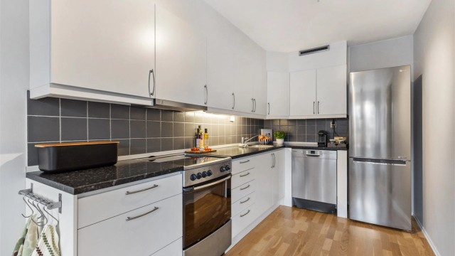 Kjøkkenet har en tidløs innredning med glatte fronter og godt med skap- og benkeplass.