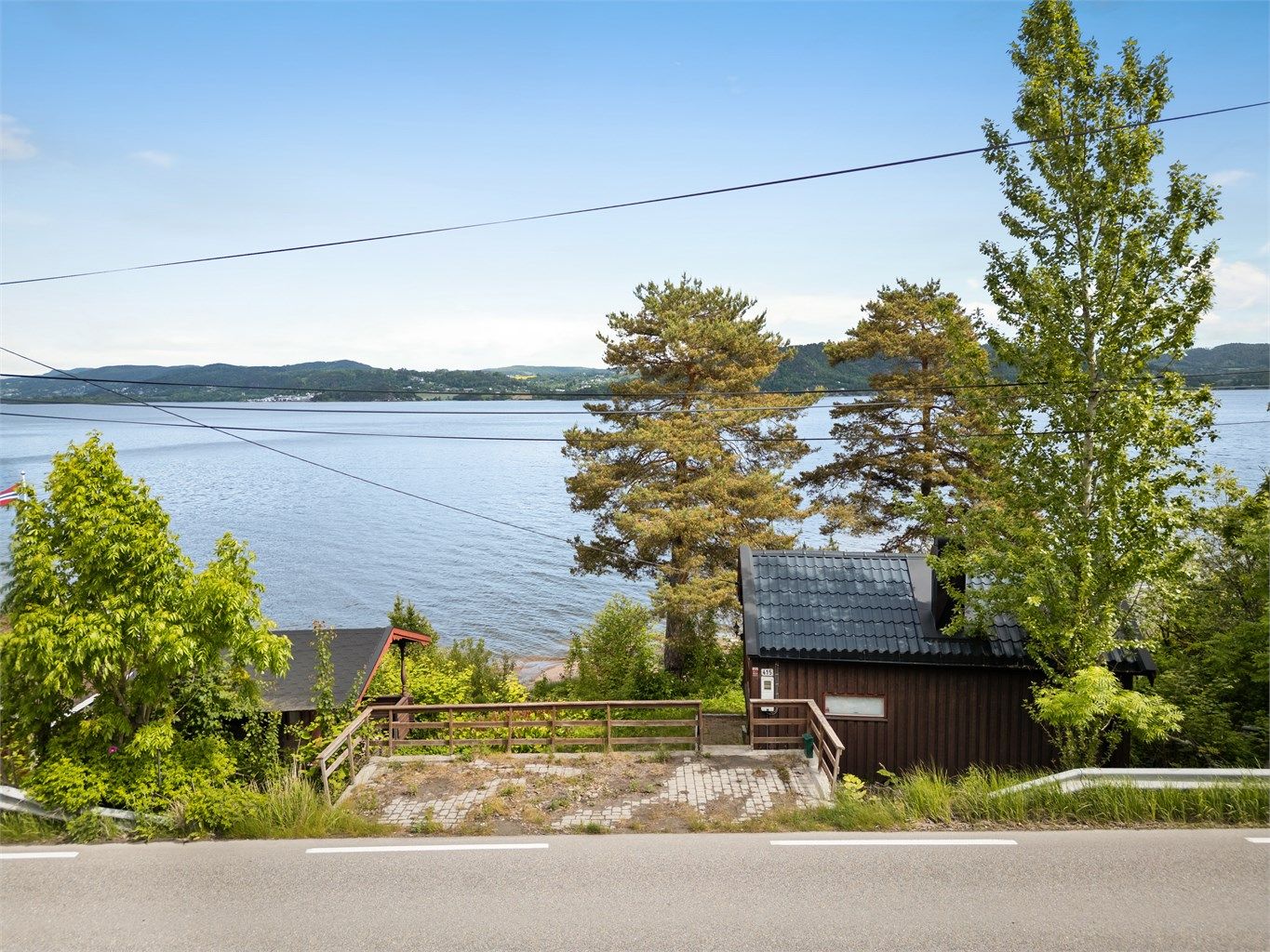 Parkeringsplass langs Svelvikveien. Del av parkeringsplassen er opparbeidet utenfor tomtegrensen.
