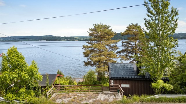 Parkeringsplass langs Svelvikveien. Del av parkeringsplassen er opparbeidet utenfor tomtegrensen.