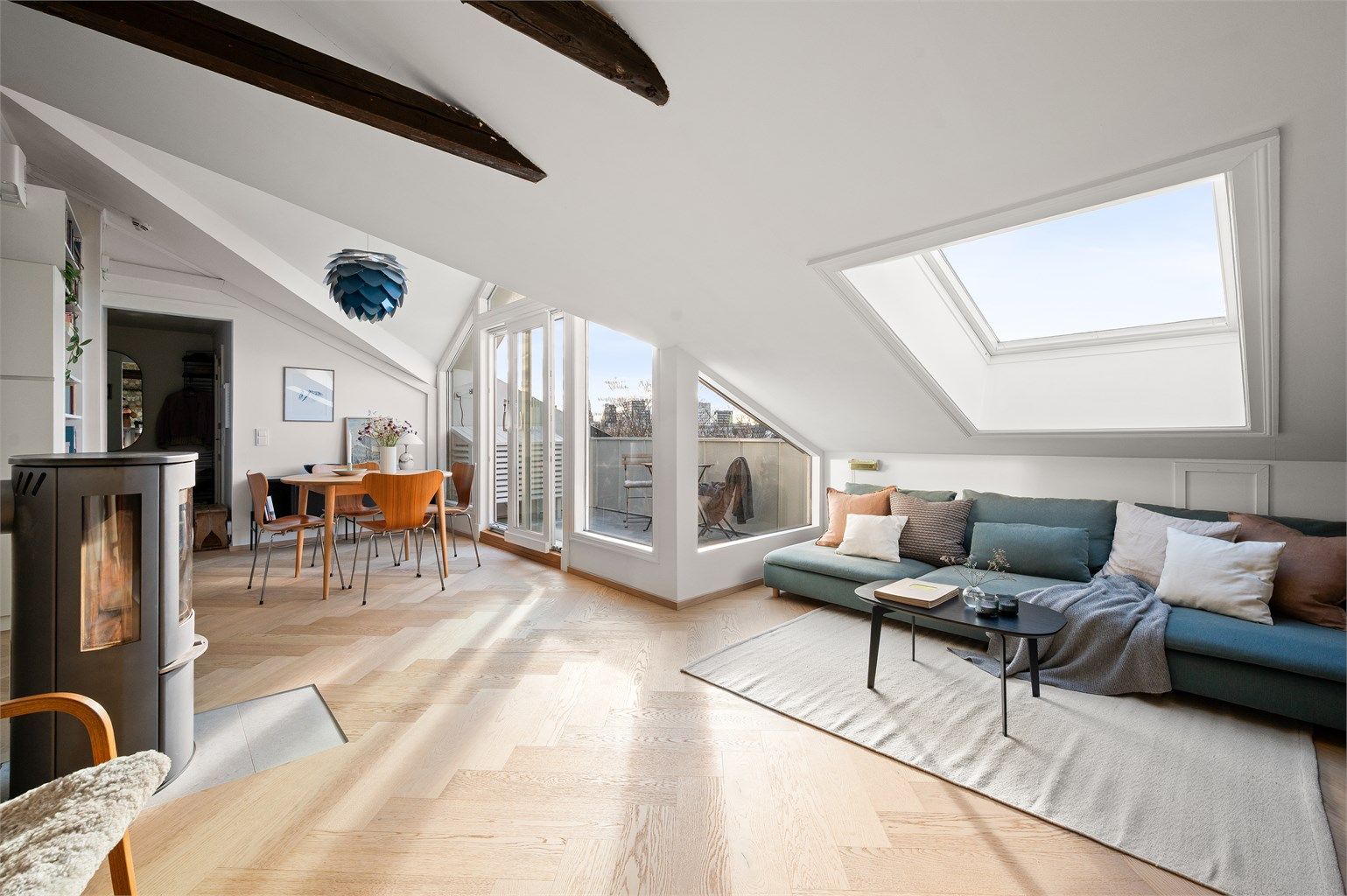 Store vindusflater og takvindu slipper inn rikelig med dagslys, supplert av en stemningsfull vedovn.