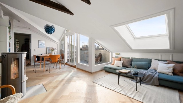 Store vindusflater og takvindu slipper inn rikelig med dagslys, supplert av en stemningsfull vedovn.