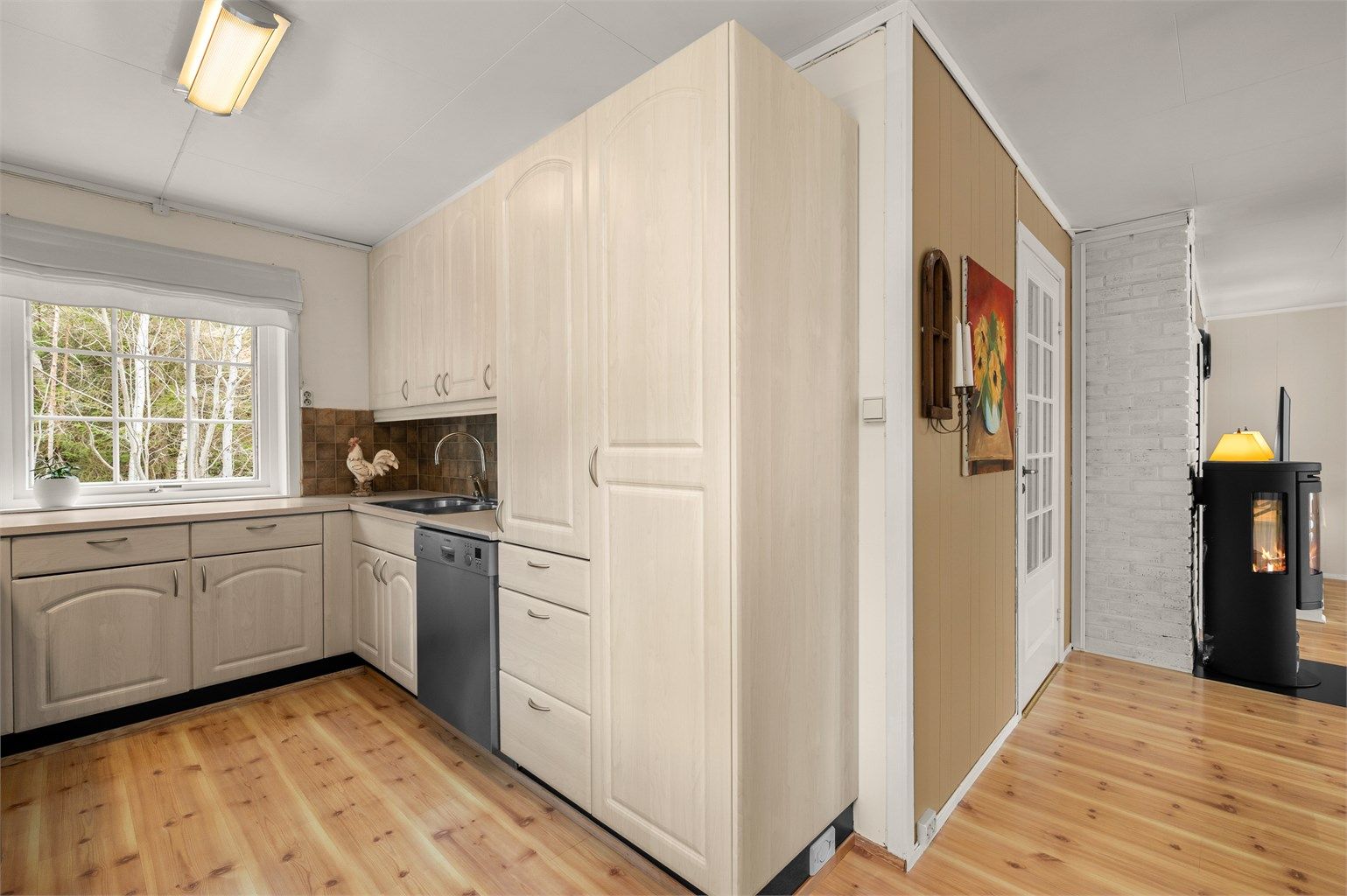 Kjøkkenet har en praktisk utforming med godt med skap- og benkeplass, samt kort avstand til spiseplassen like ved.