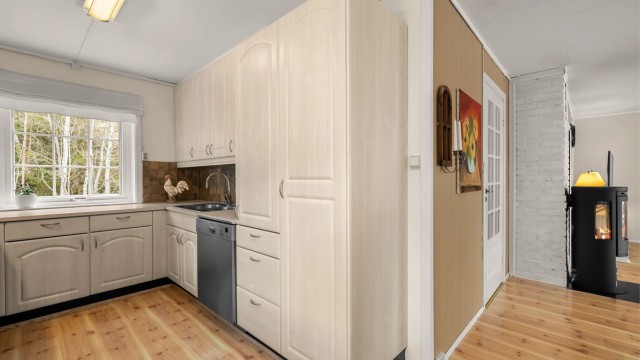 Kjøkkenet har en praktisk utforming med godt med skap- og benkeplass, samt kort avstand til spiseplassen like ved.