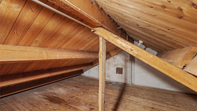 Uinnredet kaldtloft med synlige taksperrer og rikelig med lagringsplass.