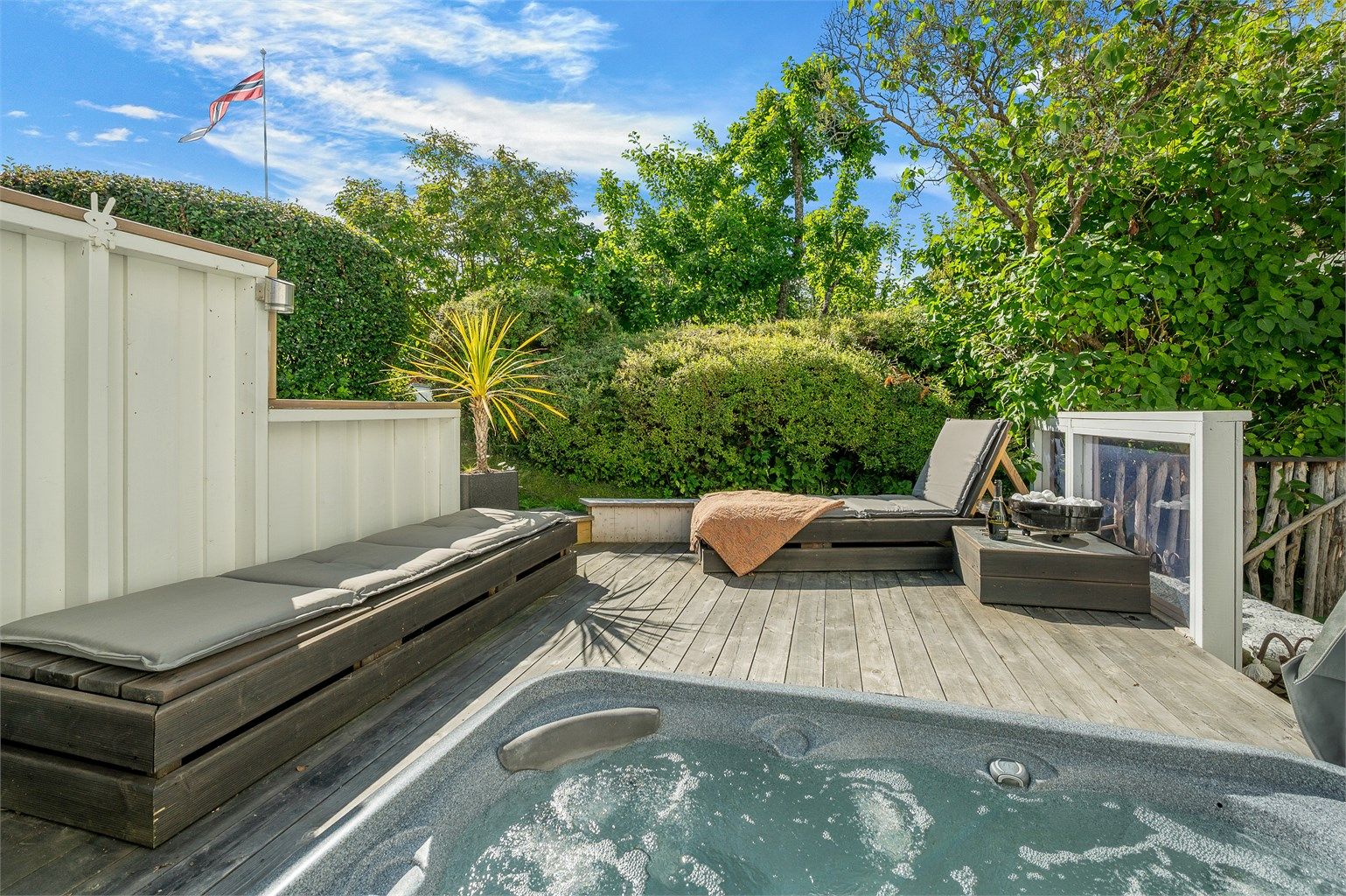 Usjenert terrasse med jacuzzi og gode muligheter for å nyte lange, solrike dager utendørs.