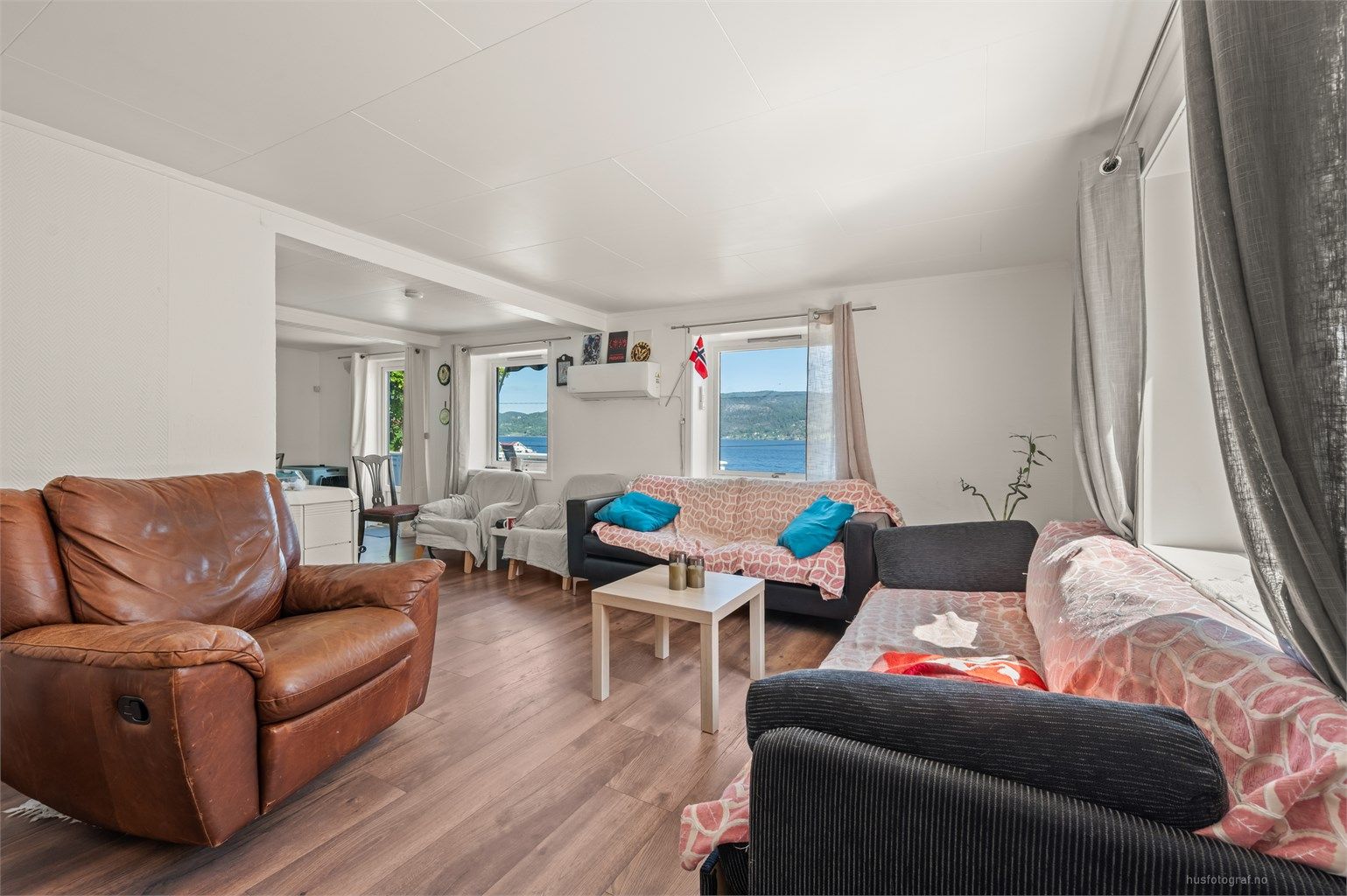Stor stue med god planløsning og lysinnslipp fra flere vinduer. Laminat på gulv og strie på vegger. Ny varmepumpe fra 2024 og lun peisovn