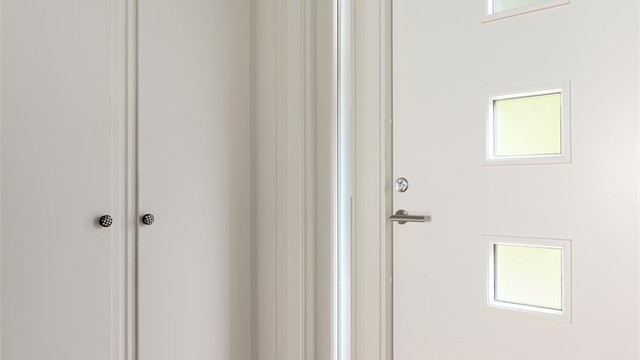 Ytterdøren til entréen har glassfelt på høykant for en elegant og moderne finish