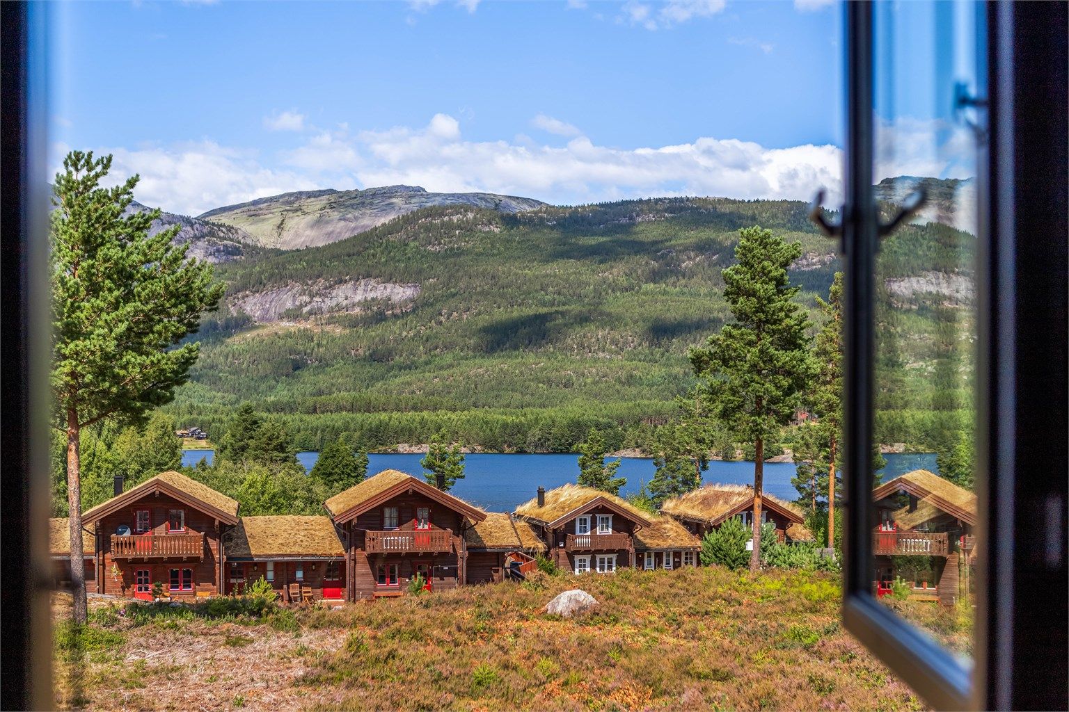 Nyt utsikten mot Vråvatn og fjellene fra vinduet.