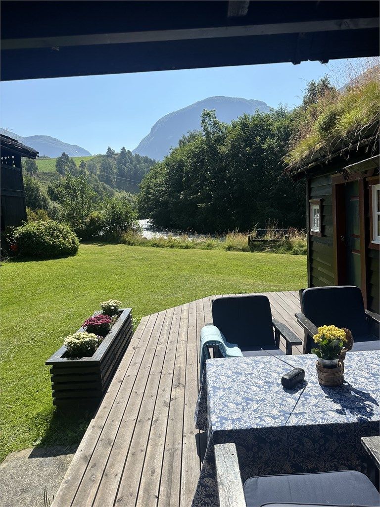 Fra en av de mange uteplassene kan du nyte utsikten mot elven og fjellene.
