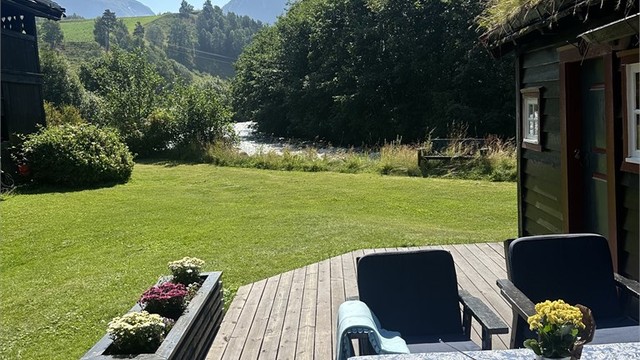 Fra en av de mange uteplassene kan du nyte utsikten mot elven og fjellene.