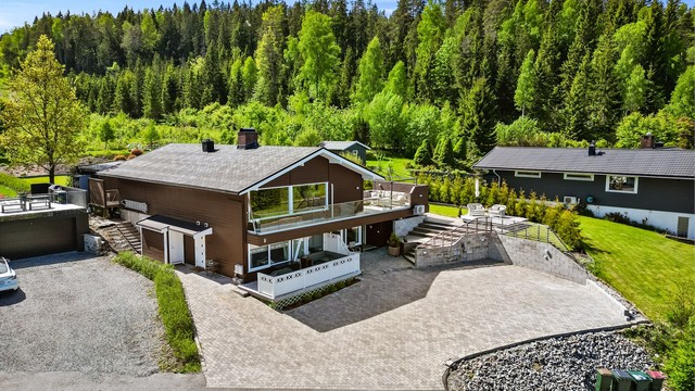 Stor gårdsplass med el-billader og disponibel garasje i rekke.
