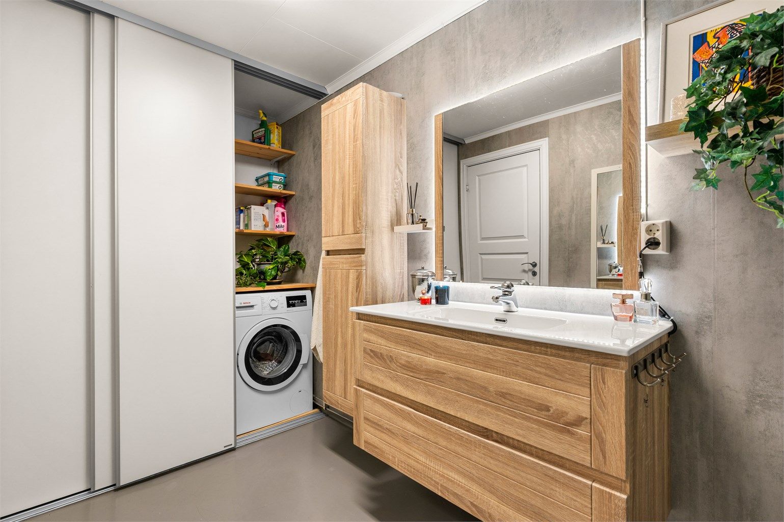Videre har badet praktisk skyvedørsgarderobe som skjuler løsning for oppvaskmaskinen. 