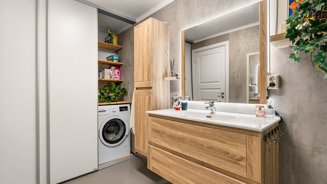 Videre har badet praktisk skyvedørsgarderobe som skjuler løsning for oppvaskmaskinen.