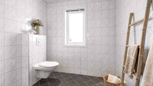 Baderommet har vegghengt toalett og åpningsbart vindu for naturlig utlufting.