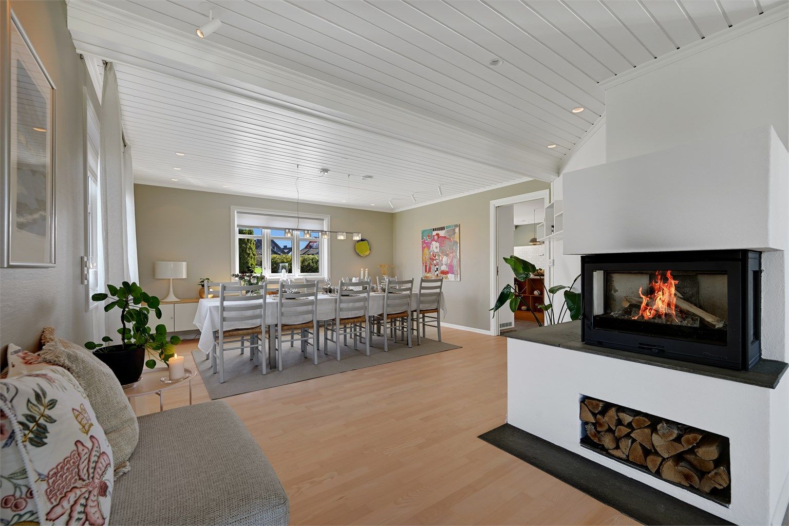 Peisen med innsats skaper en lun atmosfære og fungerer som en naturlig romdeler mot spisestuen.