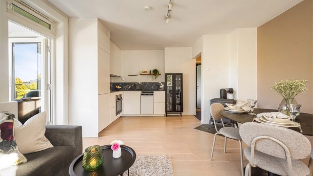 Stuen er lys og romslig, med takhøyde på 2,48 meter, en-stavs parkett og åpen kjøkkenløsning, og det er god plass til både sofa og spisebord.