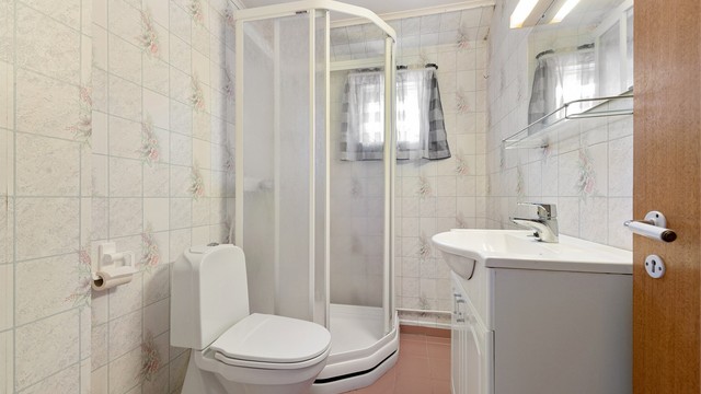 Badet i 2. etasje har flislagt gulv, dusjkabinett og toalett