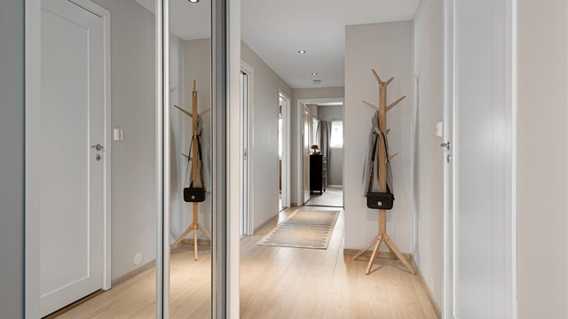 Entré med skyvedørsgarderobe med speilfronter og innfelte spotter i himling.