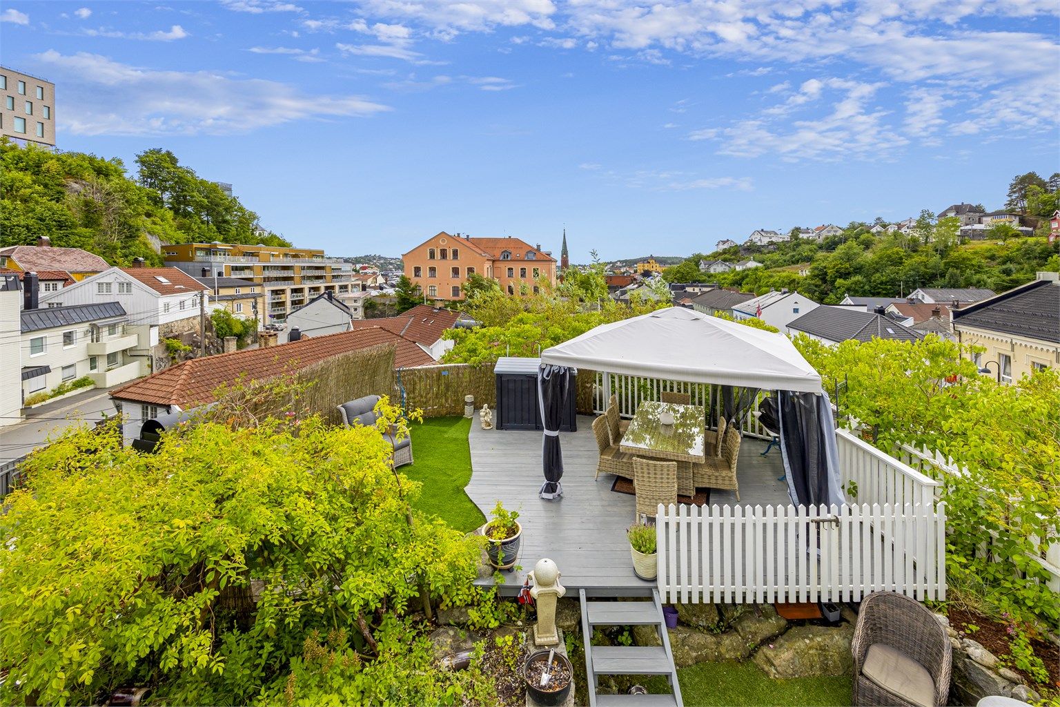 Uteplassen bak boligen er opparbeidet med terrasser og diverse planter og blomster. Hyggelig "oase" midt i sentrum med fin utsikt. 