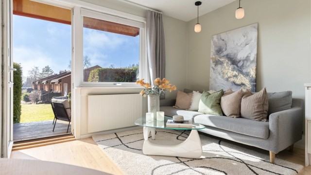 Stuen har plass til en sofagruppe og oppbevaringsmøbler. Oppvarming skjer via vannbårne radiatorer.