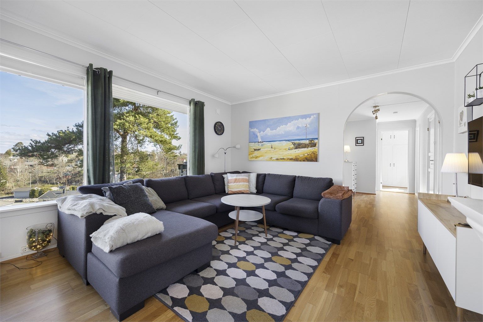 Stuen er romslig og har plass til både en stor sofagruppe og en egen spiseavdeling.