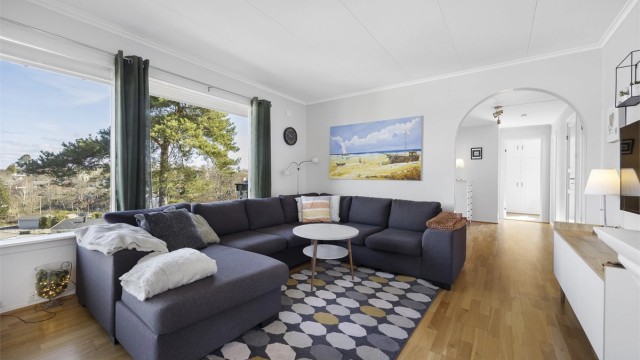 Stuen er romslig og har plass til både en stor sofagruppe og en egen spiseavdeling.