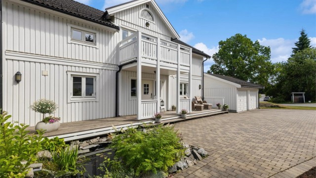 Boligen har en klassisk arkitektur og fremstår som svært godt vedlikeholdt. Legg også merke til den sjarmerende karpedammen som bidrar til et hyggelig uterom.