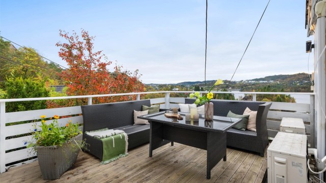 Terrasse med god plass til flere sittegrupper og utemøblement.