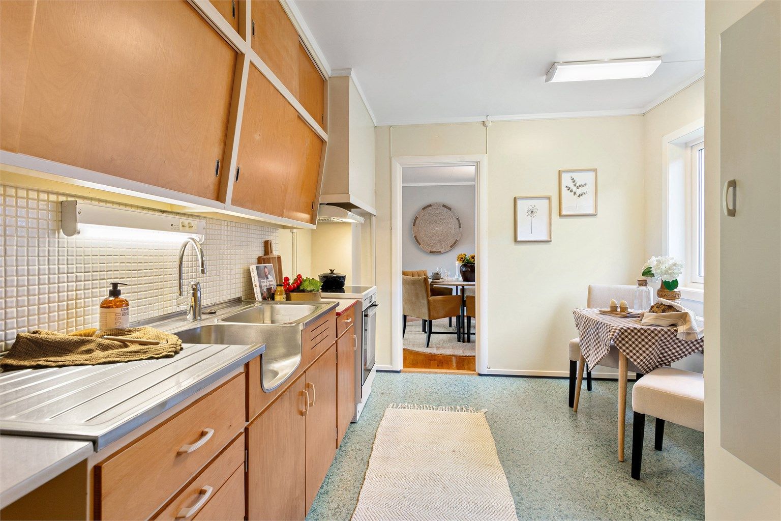 Original plassbygd innredning med slette fronter. Benkeplater med laminert overflate og benkebeslag med oppvaskkum og utslagsvask.