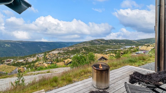 Stor terrasseplatting i kebony med åpen utsikt mot fjellheimen og Kvitåvatn.