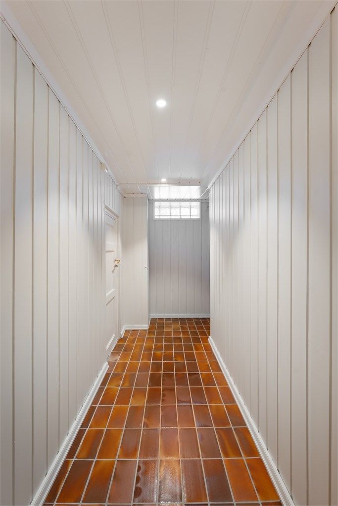 Kjellergangen har flislagt gulv og binder sammen rommene i underetasjen.