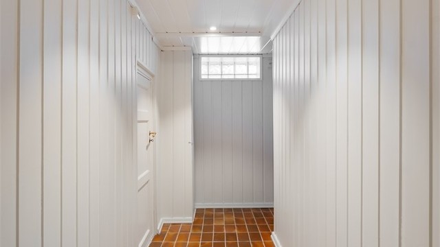 Kjellergangen har flislagt gulv og binder sammen rommene i underetasjen.