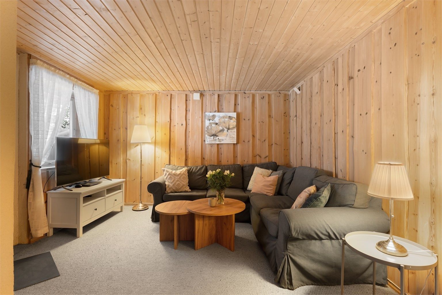 Kjellerstuen gir ekstra spillerom for familien, med panel på vegger og teppe på gulv.