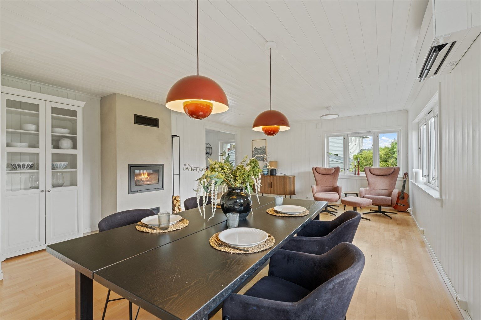 Stuen er innredet med peisovn og varmepumpe, og har god plass til både spisebord og sofagruppe.
Foto: Martin Nordbø