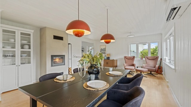Stuen er innredet med peisovn og varmepumpe, og har god plass til både spisebord og sofagruppe.
Foto: Martin Nordbø