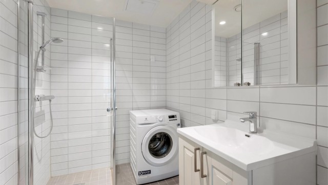 Her er det dusjhjørne med innfellbare glassdører og opplegg for vaskemaskin.