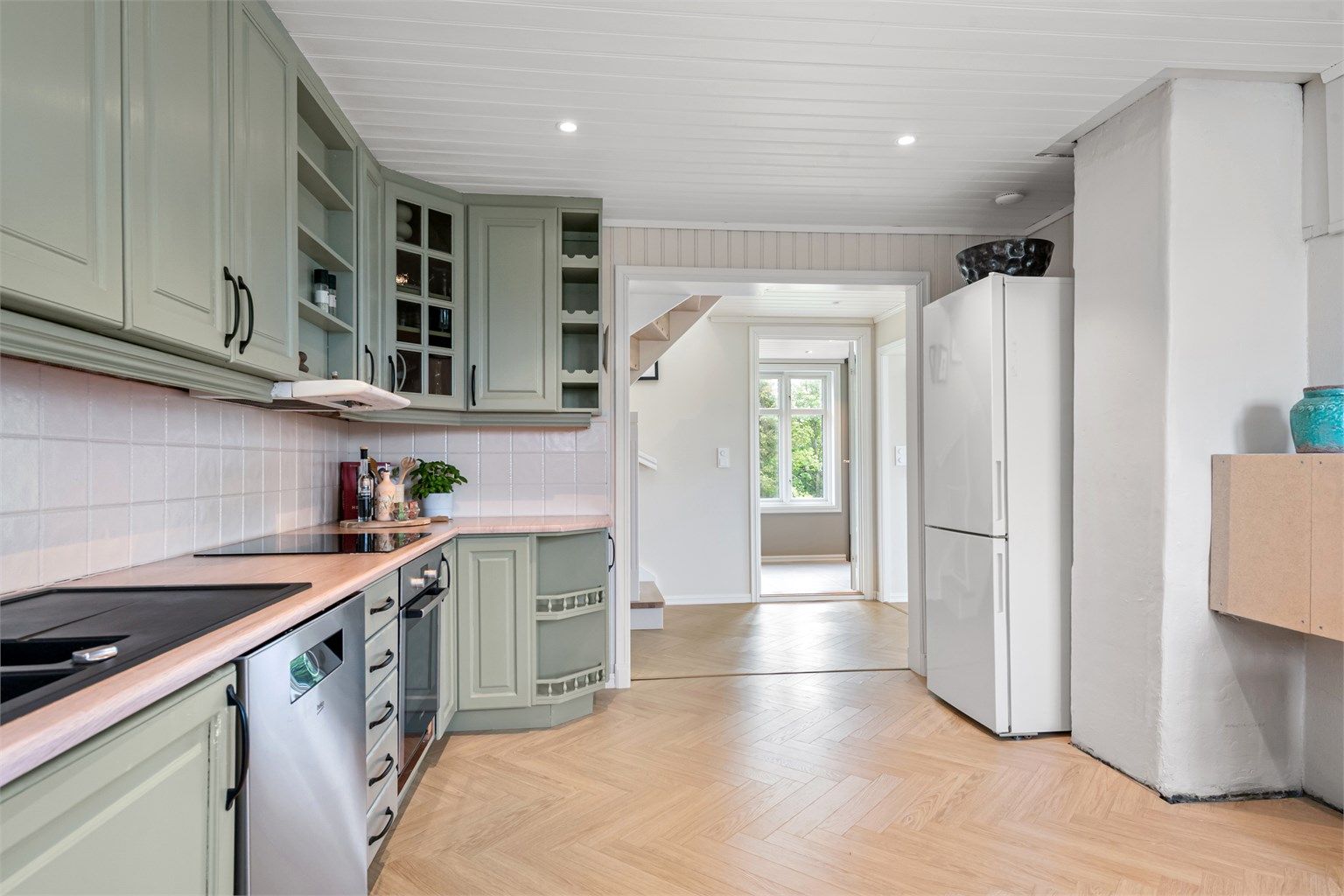 Downlights i taket gir god arbeidsbelysning, og det er fliser mellom benk og overskap.