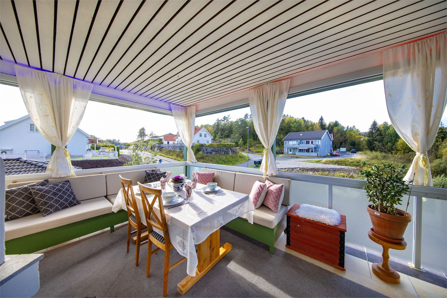 Fra stuen er det utgang til en innglasset og overbygget veranda. Vindusglassene kan skyves helt til siden om ønskelig.