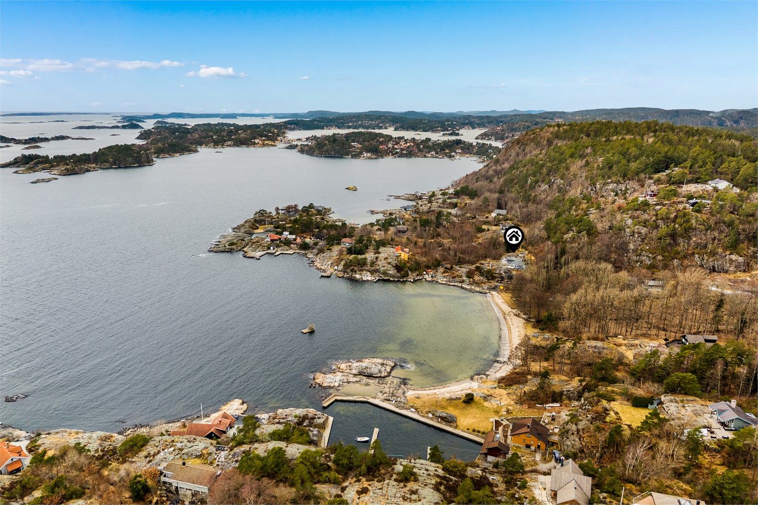 Fritidseiendommen ligger nydelig til med svaberg, strand og brygge rett nedenfor.